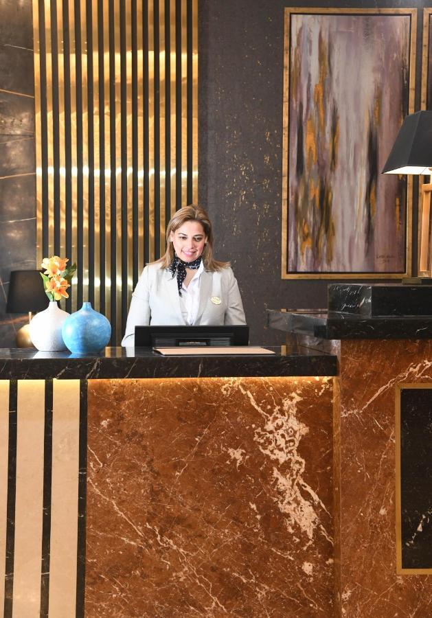 Tolip Gardens Hotel Il Il Cairo Esterno foto A hotel receptionist at the front desk